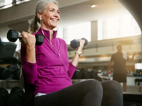 A woman lifting weights in the gym.