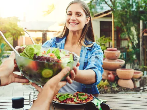 A woman eating a healthy meal with friends.