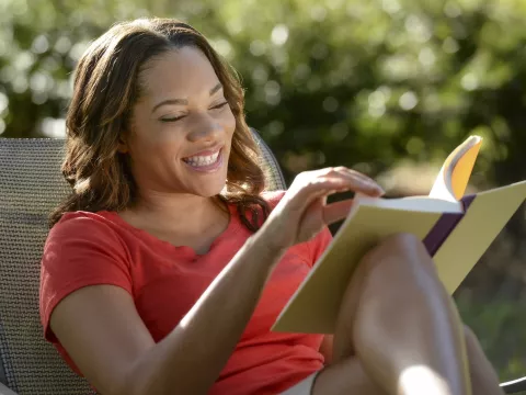 A woman reading outdoors.