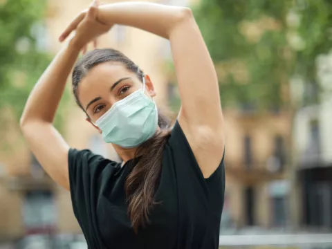 A woman stretching outside after a workout.