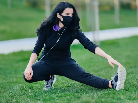 A woman stretching outdoors.