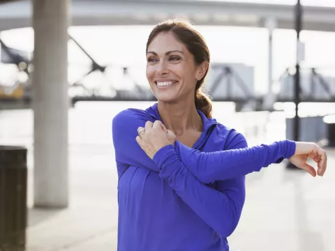 A woman stretching her shoulder.