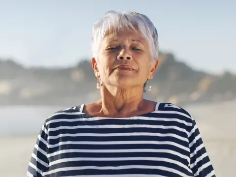A woman taking a deep breath.