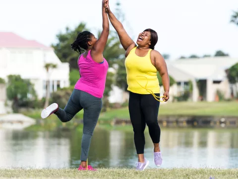 Two women high-five after a great workout outside.