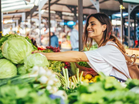 Young woman explores the farmers market for the best produce