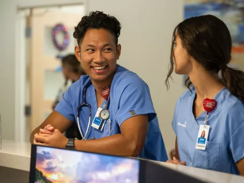 two adventhealth nurses looking at each other, smiling