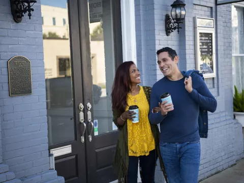 Hispanic Couple walking outdoors with coffee