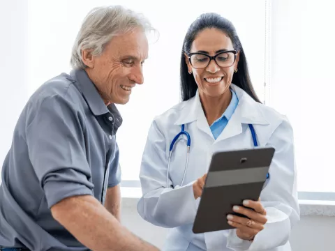 An older man speaking to a female physician.