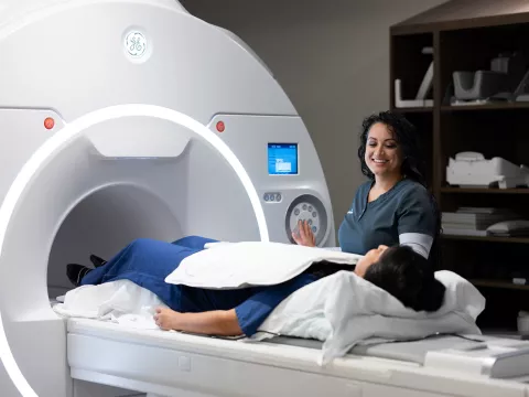 A imaging technician talking with a patient about to get a MRI.