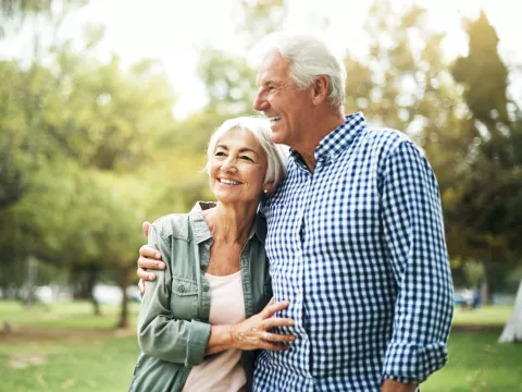 A Senior Couple Hugs in the Woods