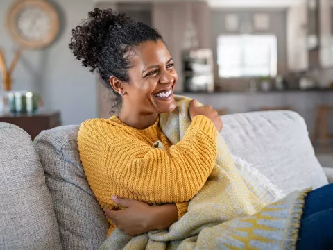 A woman smiling on her couch