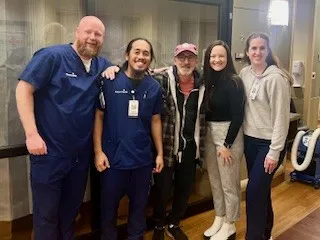 Former patient poses with nurses in the ICU