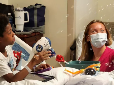 King, a nine-year-old pediatric patient at AdventHealth Tampa, explores toys purchased through The Toy Foundation Play Grants Program.