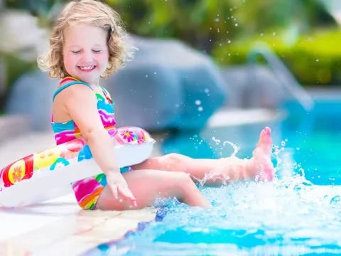 Little girl splashing around in a swimming pool