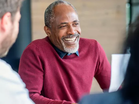 Middle aged man with beard and sweater smiling
