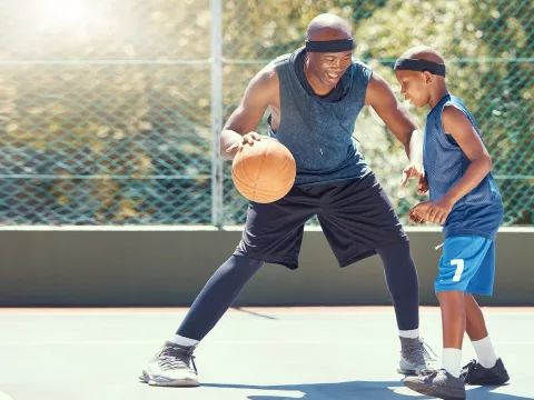 A Father and Son Play Basketball on a outdoor court