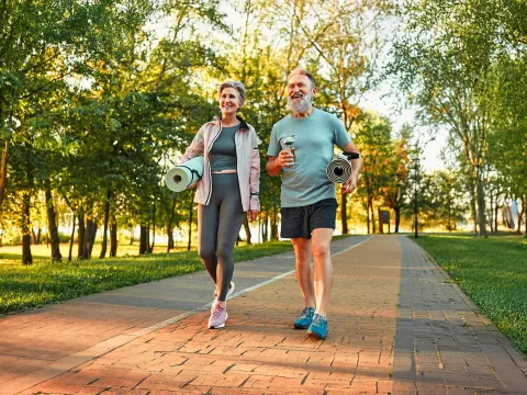 Senior Couple Walking and Talking Through a Park