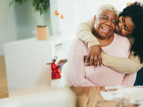 Seated mother embraced by daughter