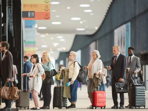 A group of people waiting to check in at the airport.