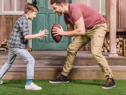 Father and son playing a backyard game of football.