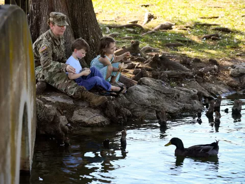 Military mom in uniform sitting with her kids in the park
