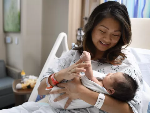 Mother holding her newborn baby in a hospital bed
