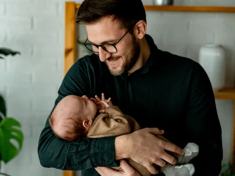 A new father holds his baby.