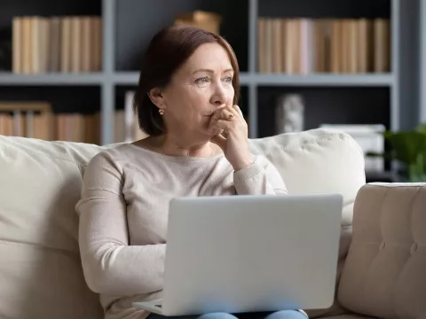 A woman thinking while on her laptop