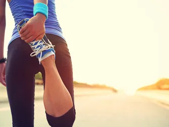 A runner stretches her leg.