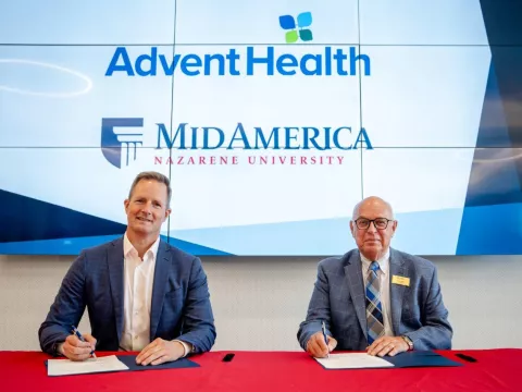 Two men signing documents