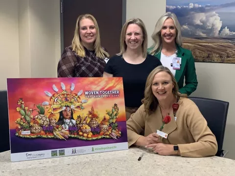 Four women next to a poster.