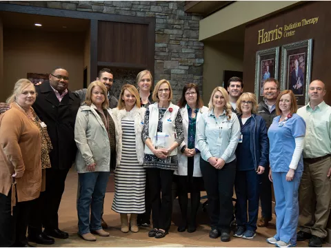 A group of women and male standing together.