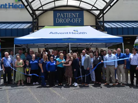 a group gathers to cut the ribbon to celebrate cedartown clinic opening