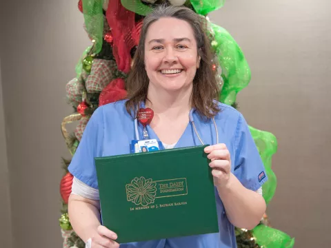 Tina Moore holding her Daisy Award