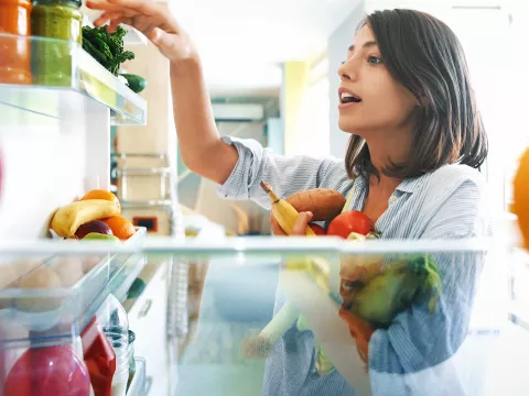 Woman cleaning out refrigerator