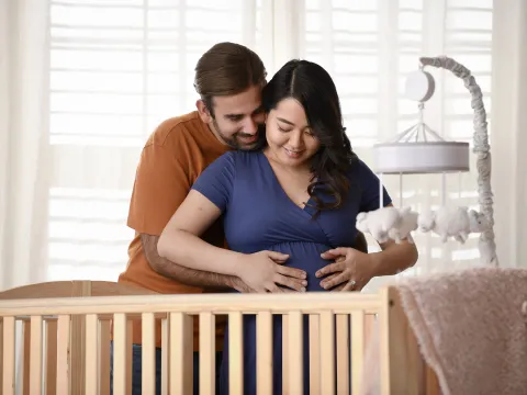 Happy expectant parents embracing