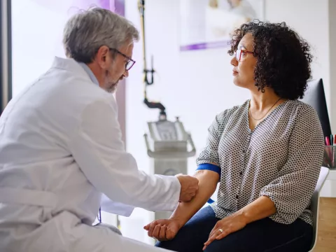 A woman getting a blood test performed by a physician