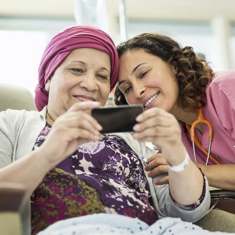 A young nurse and her female cancer patient taking a sweet selfie.