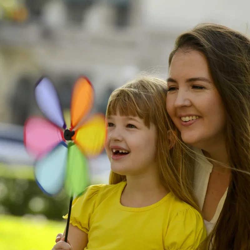 Mom and daughter playing with a pinwheel.