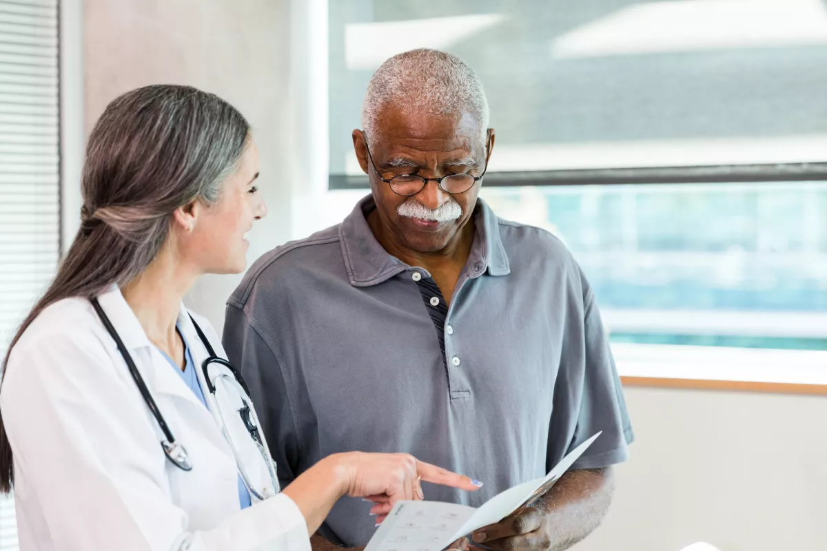 A Physician Goes Over a Chart with a Patient 