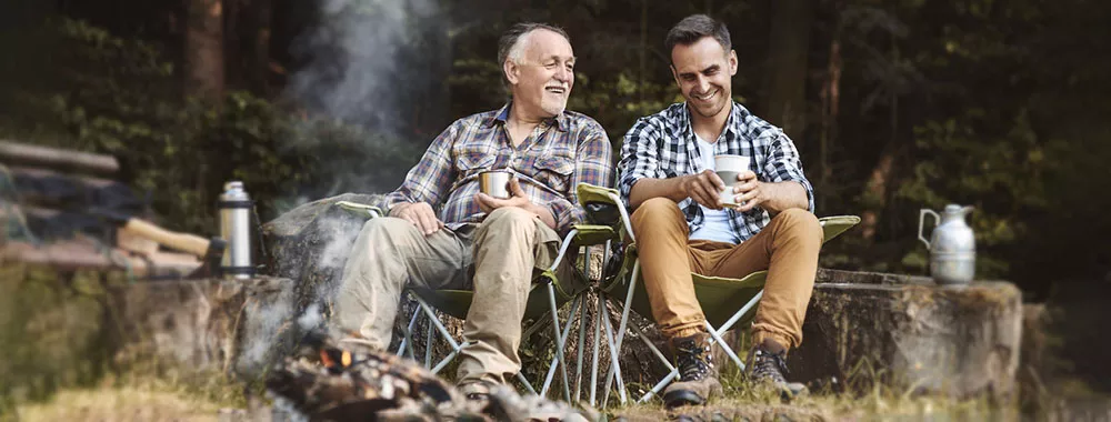 Two men sit in front of a fire and talk about their health