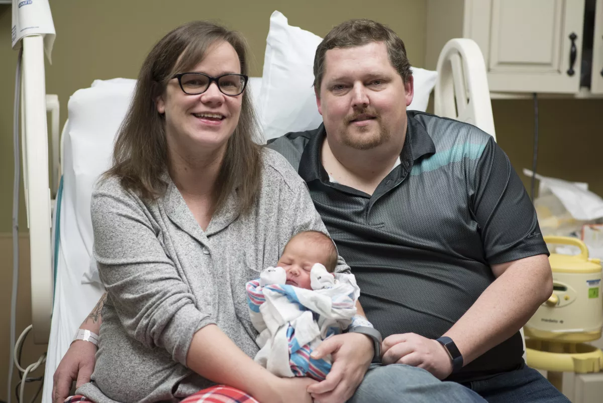 mother and father holding a baby