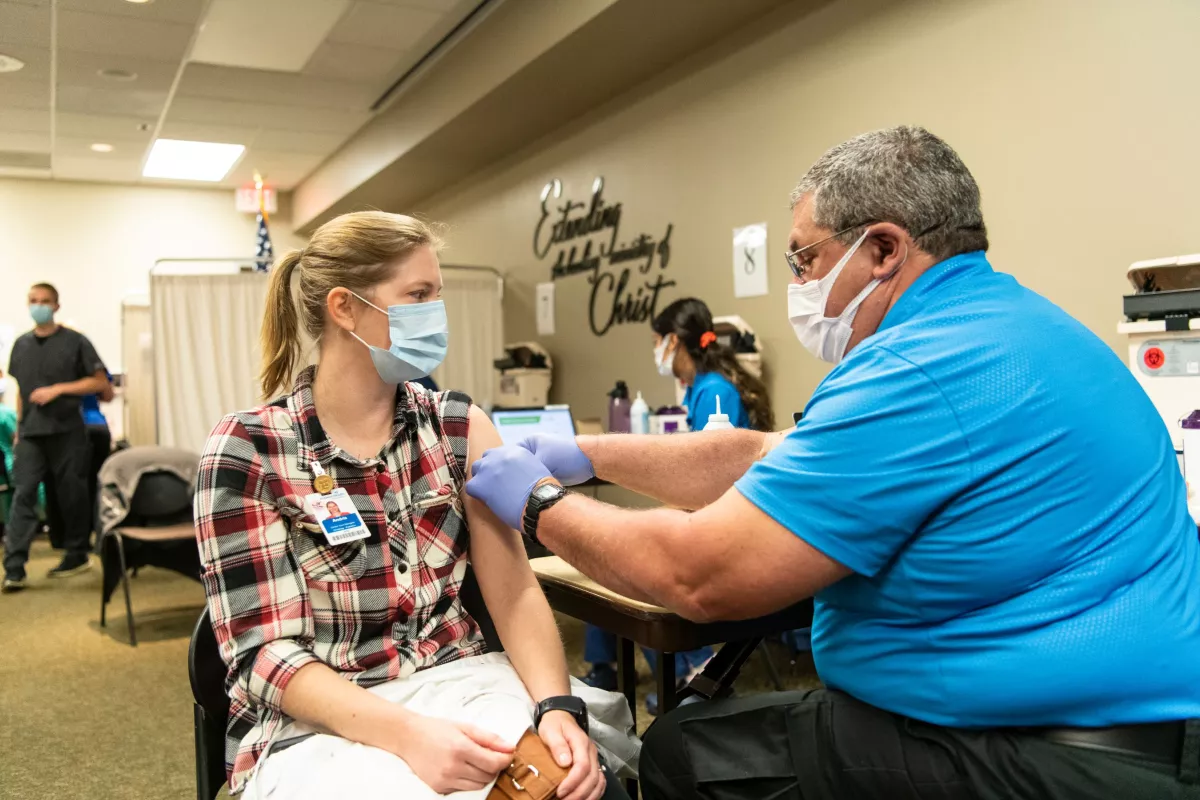 Female AdventHealth employee receives Moderna vaccine from male employee