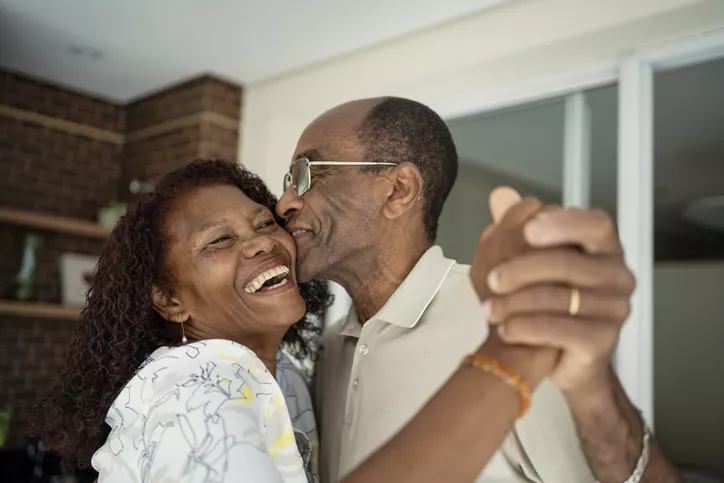 African American senior couple dancing on the balcony 