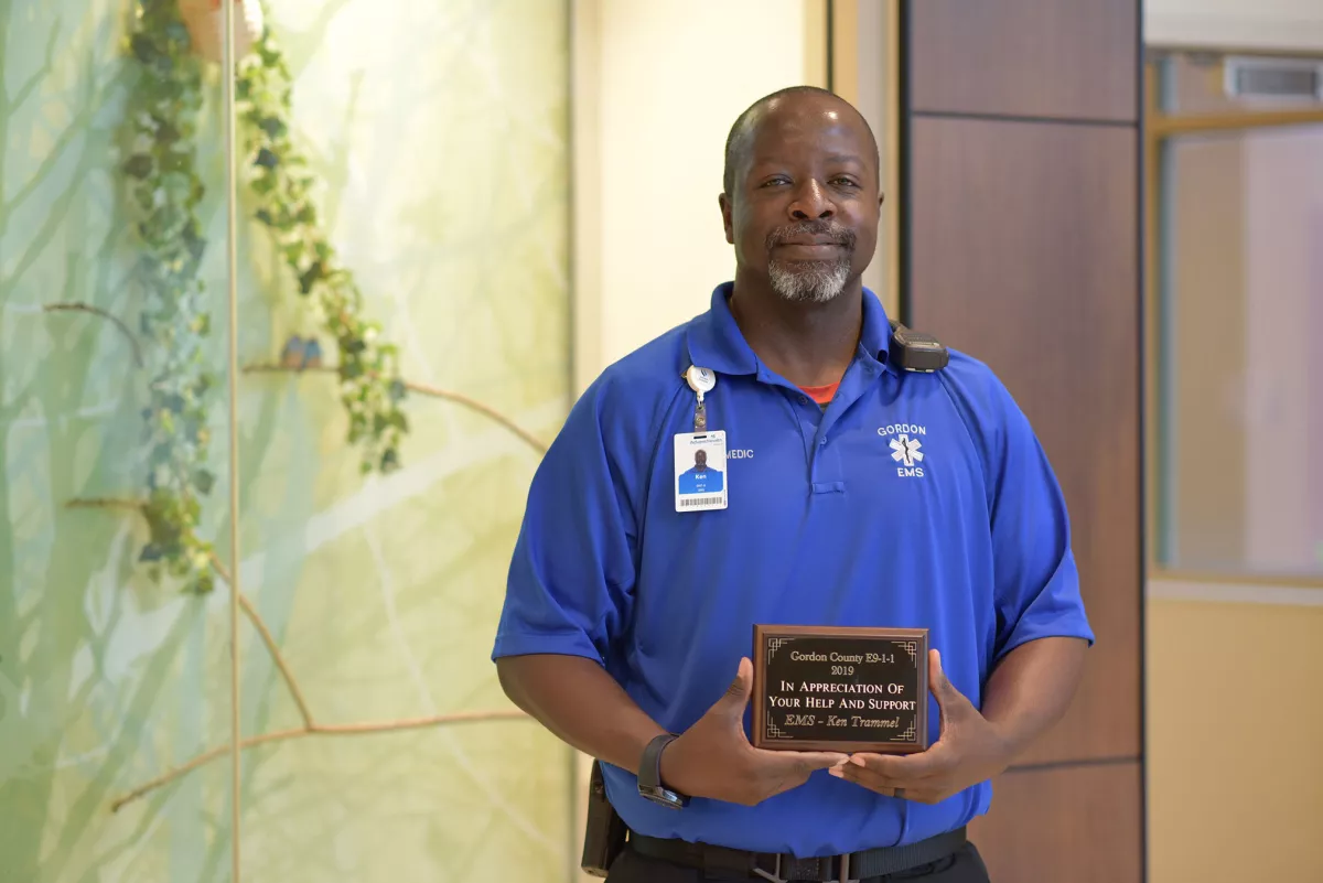 AdventHealth worker, Ken Tramell, holding his award plaque