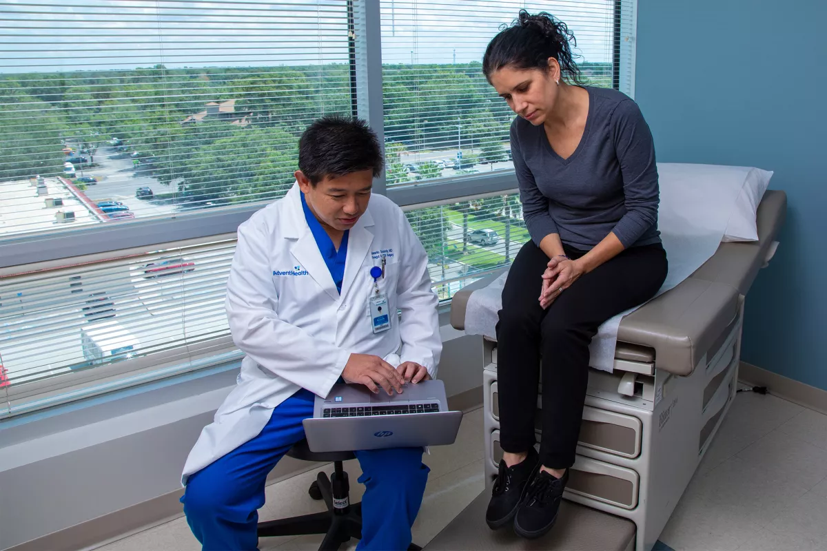 Dr. Iswanto Sucandy showing patient a something on a laptop.