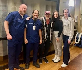 Former patient poses with nurses in the ICU