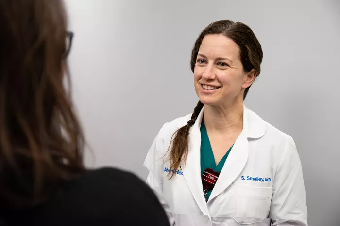 Dr. Sally Smalley speaks to a patient about her throat.