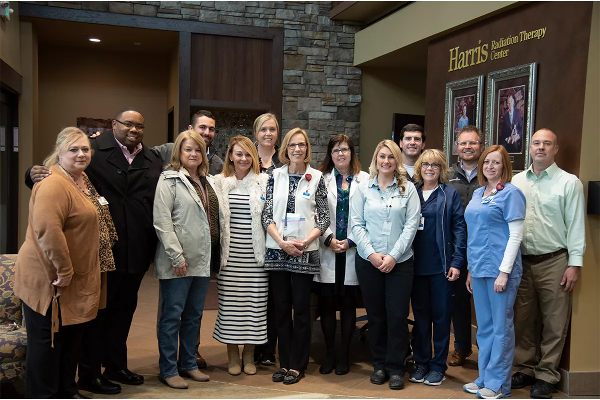 A group of women and male standing together.