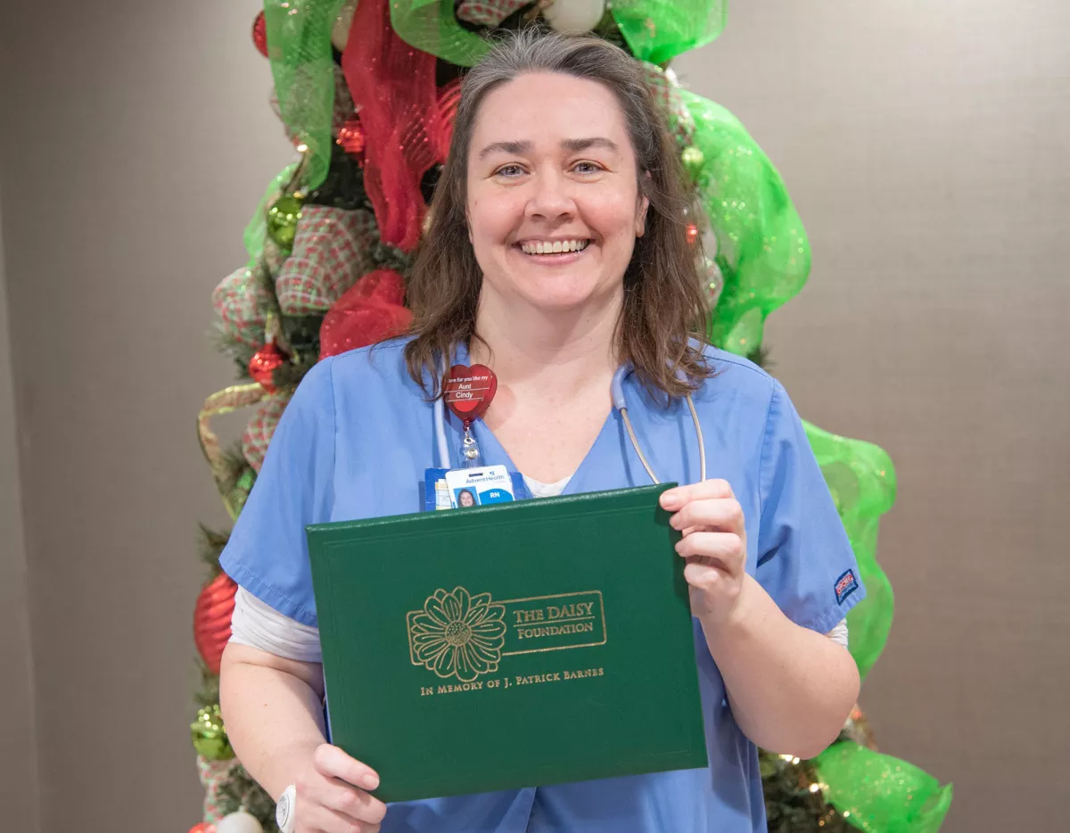 Tina Moore holding her Daisy Award